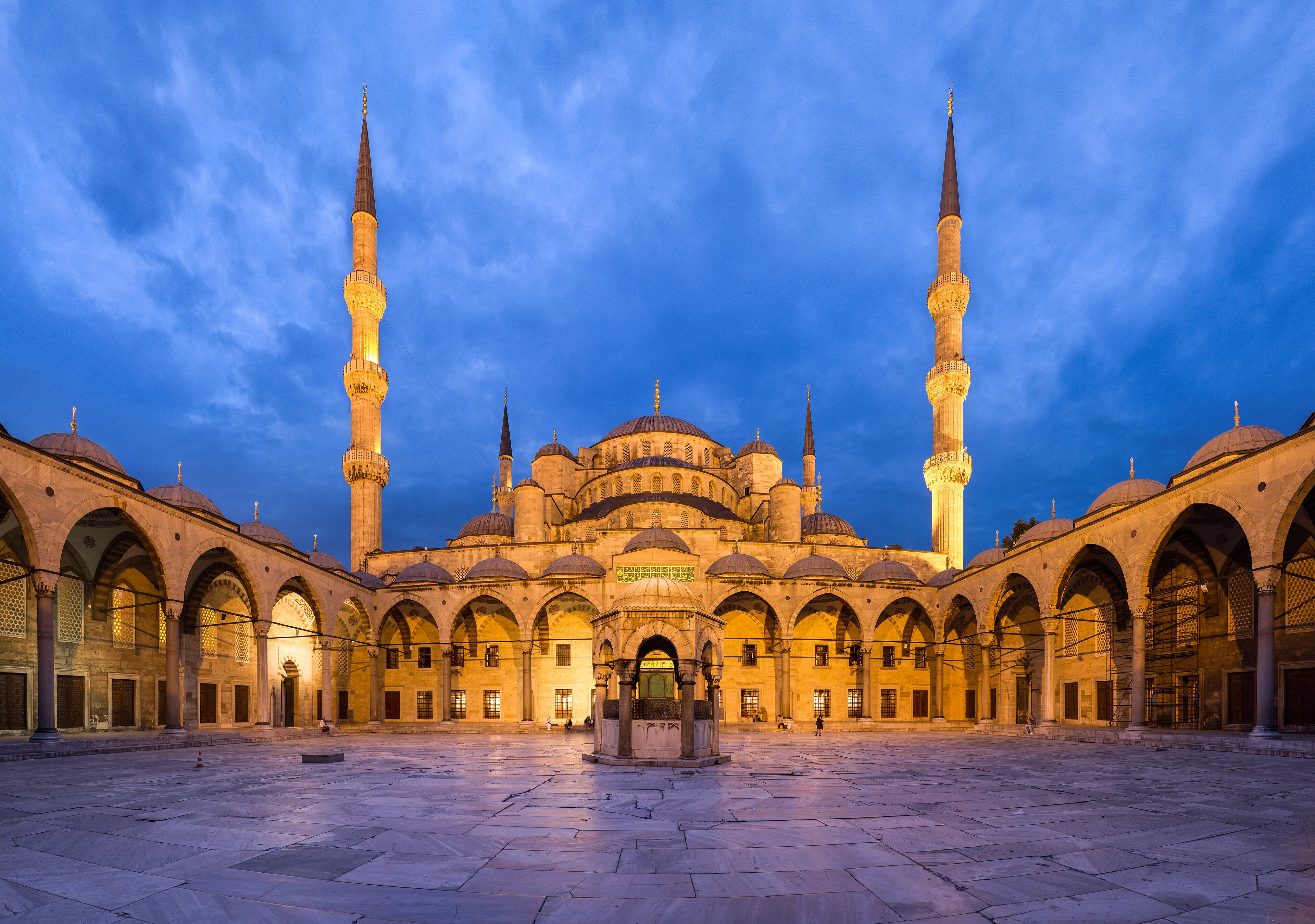 The Blue Mosque (Sultan Ahmed Mosque) courtyard at dusk, illuminated against a deep blue sky
