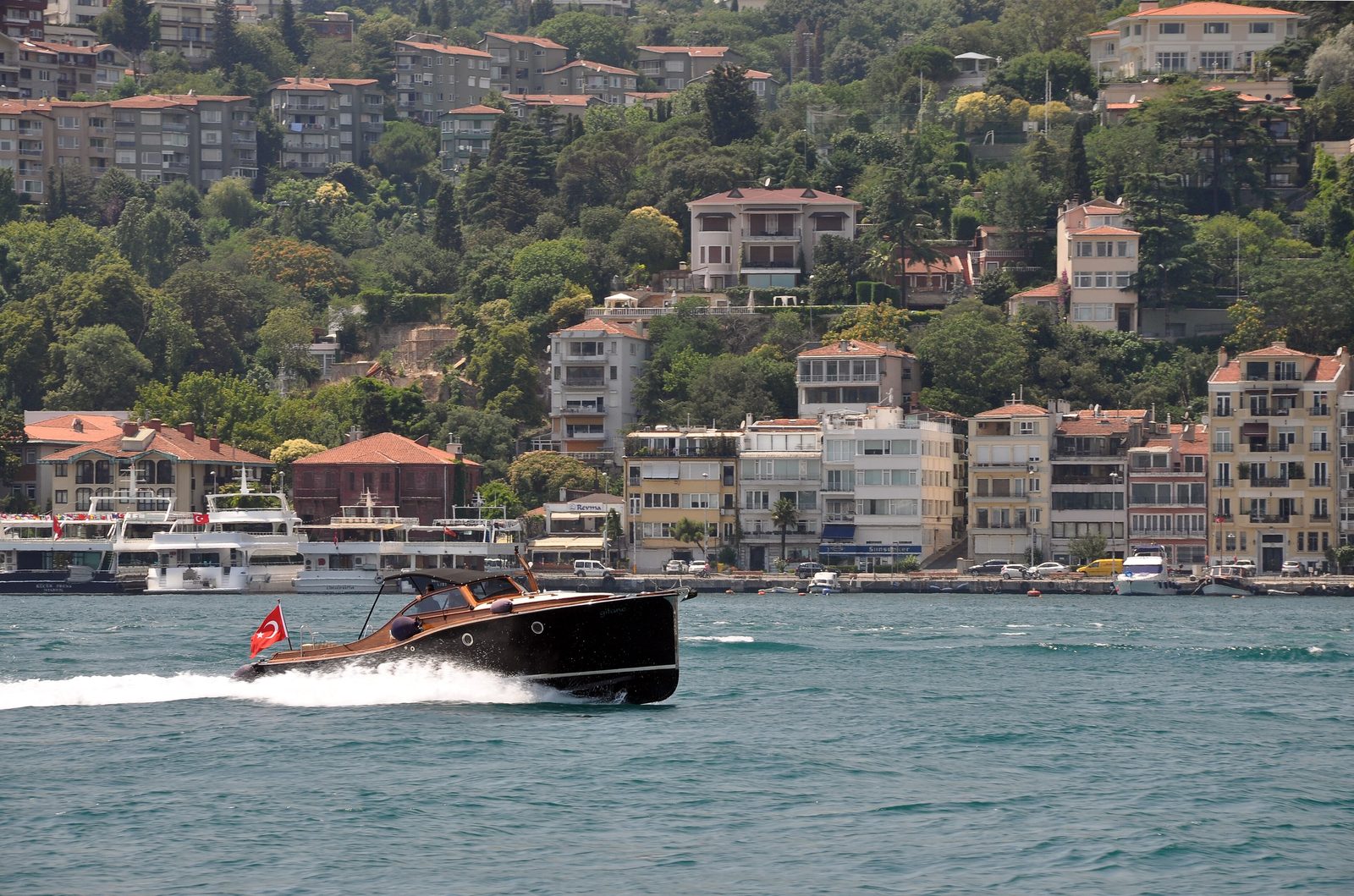 The Arnavutköy yalı row on the Bosphorus — a line of pastel-painted 19th-century timber waterfront mansions seen from the water